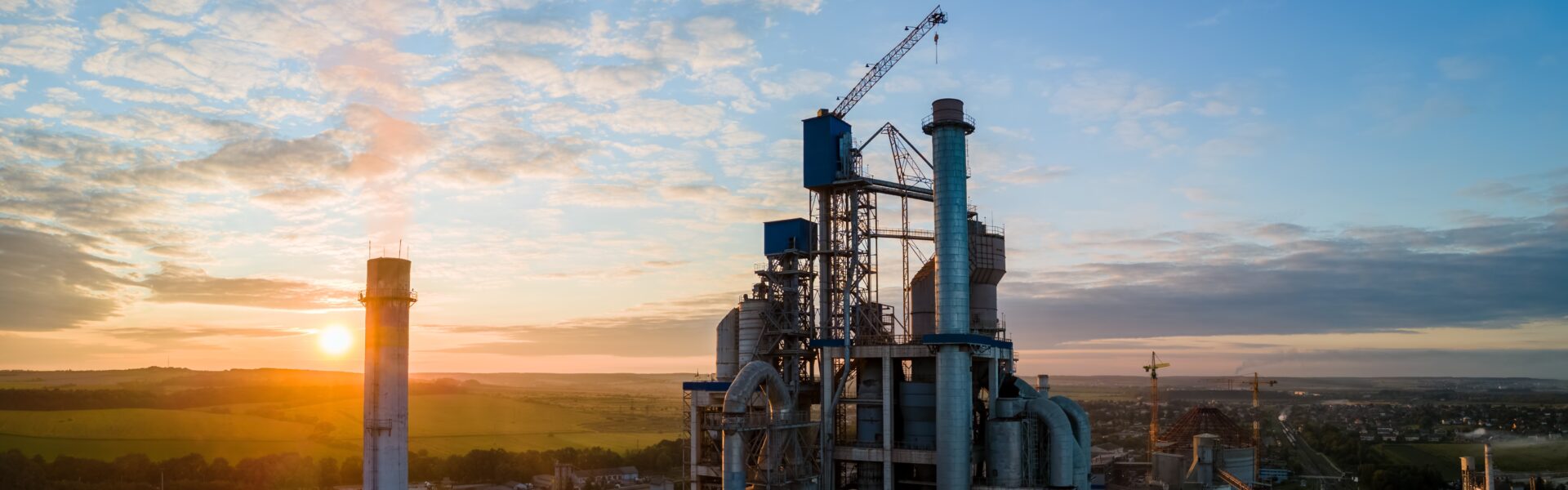 Aerial view of cement factory tower with high concrete plant structure at industrial production area. Manufacturing and global industry concept.