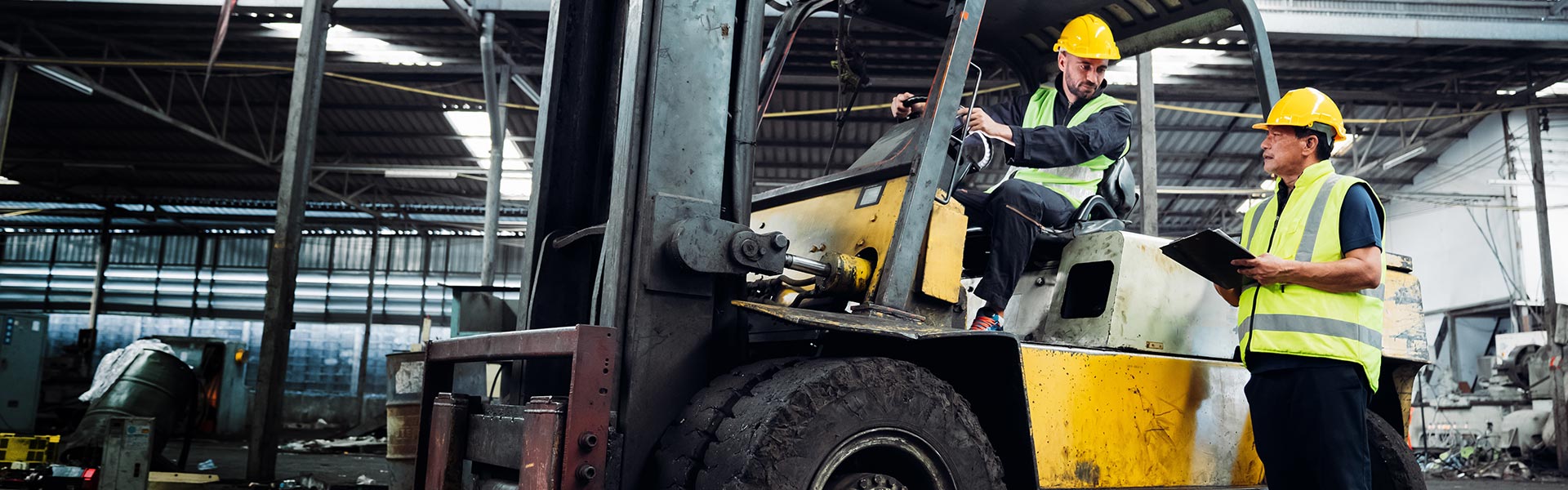 two men in security gear next to a forklift